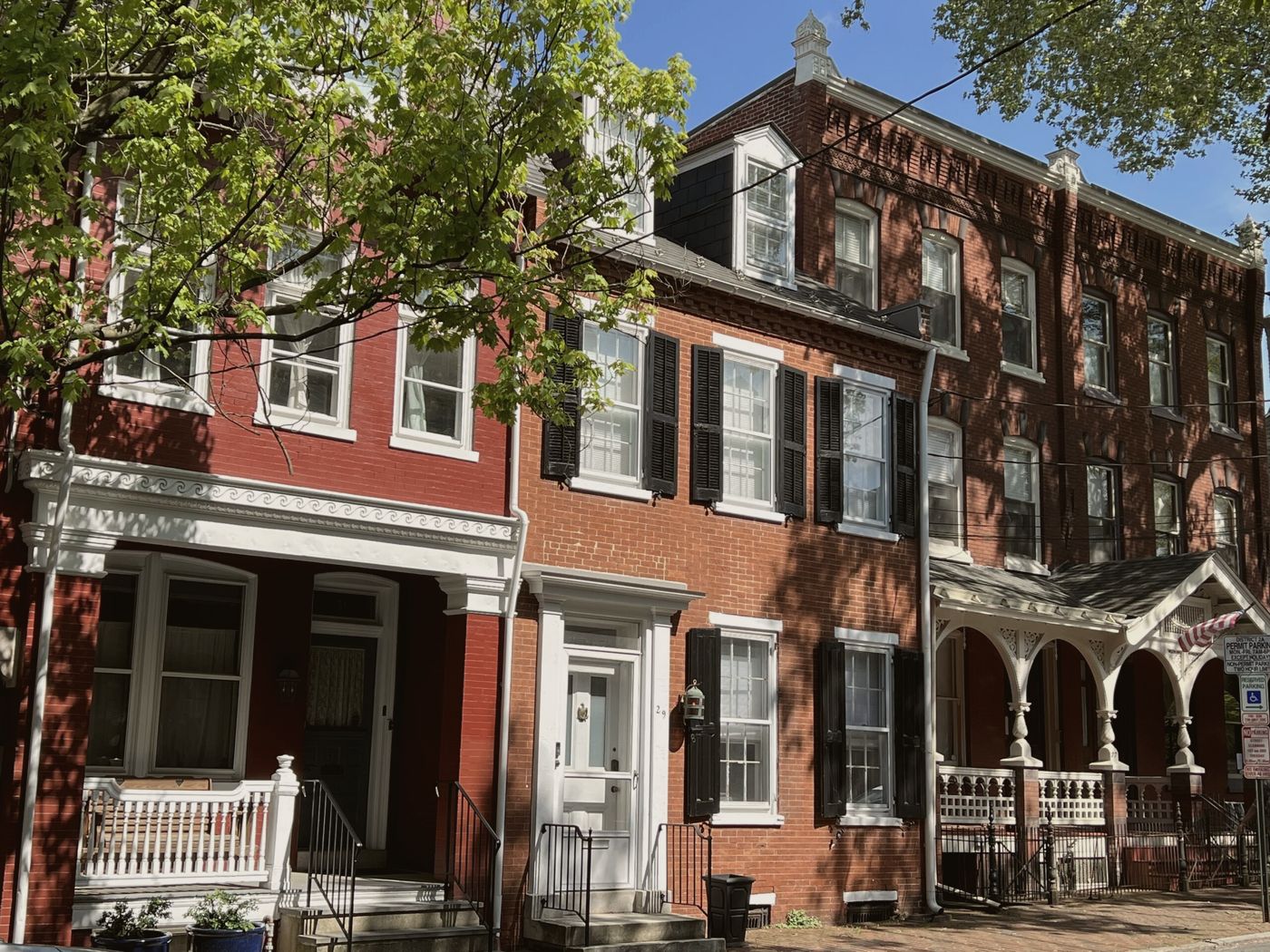 Brick rowhouses and porches on a leafy street in downtown Lancaster