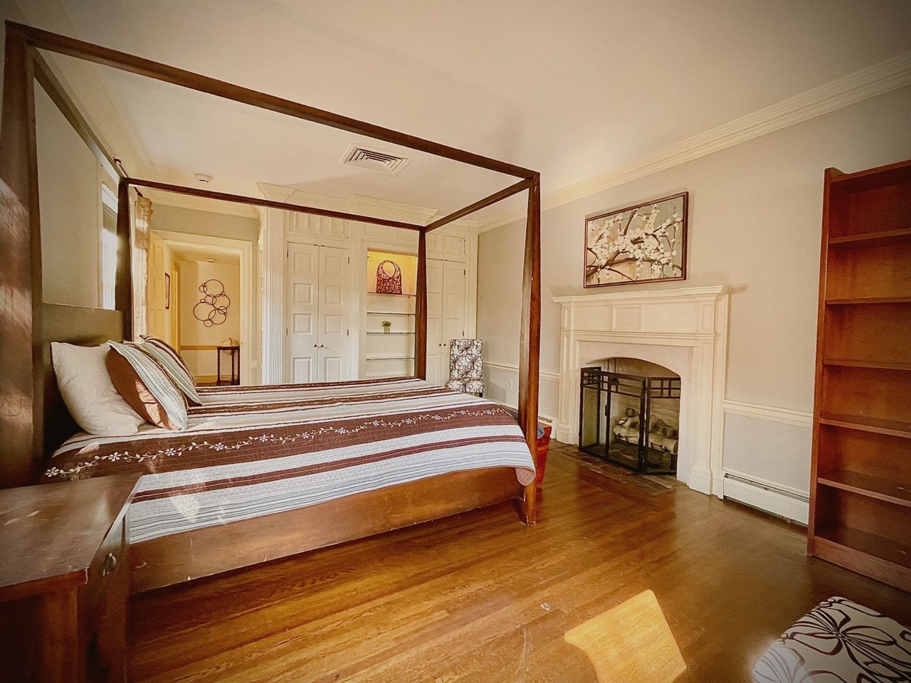 Luxury executive suite in a restored historic home, with a four-poster bed and fireplace