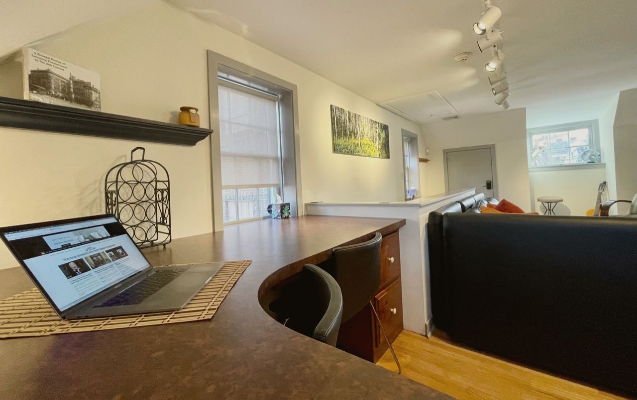 A private workspace in a PorchLight residence, laptop open on a curved desk